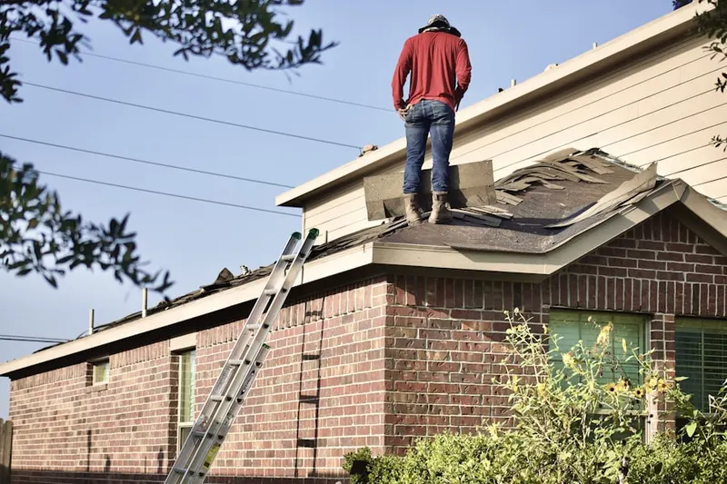 Professional roofer working on a residential roof in Fords
